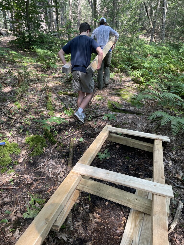 Carrying lumber to second site for new boardwalk at Hobstone Woods